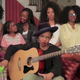 Lauryn Hill (seated) with her daughter Sarah Marley and backup singers
YouTube screenshot